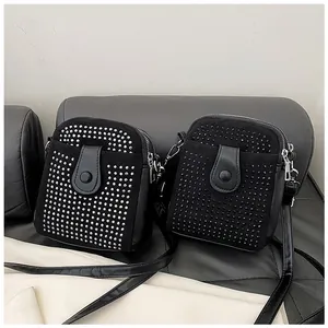 Close-up of mini crossbody bags with decorative rivets and textured faux leather finish
