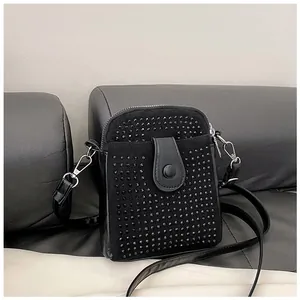 Close-up of black crossbody phone bag with rivet studs, chain strap and silver hooks