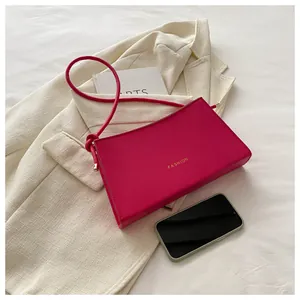 Vista dettagliata della borsa a tracolla rosa acceso con scritta Fashion dorata in pelle PU