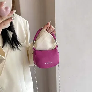 Dettaglio mini borsa magenta in pelle martellata con borchie a stella e catena argento