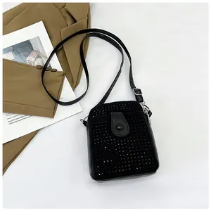 Detailed view of a black rhinestone mini crossbody bag with a sleek leather flap and strap