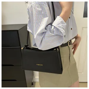 Dettaglio di una borsa a spalla nera chic con scritta FASHION dorata e finiture in metallo