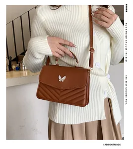 Brown quilted crossbody bag with golden butterfly lock shown as crossbody styling