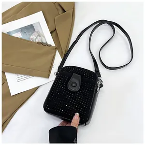 Detailed view of a black rhinestone square mini bag with a vertical crossbody strap