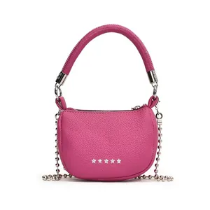Dettaglio mini borsa a mezzaluna rosso rosa con trama litchi e rivetti a stella argento