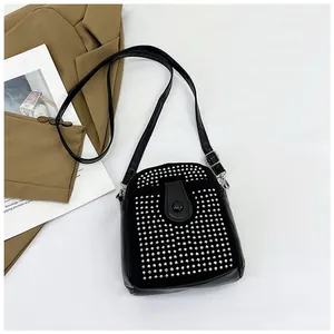 Top-down view of a black mini crossbody bag with silver rivet studs on a white background