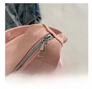 Detailed close-up of a smooth silver metal zipper on a premium pink leather tote bag