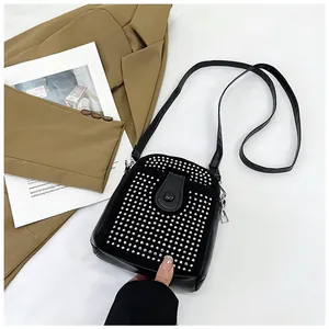 Detail view of black crossbody bag with silver studs and premium leather texture