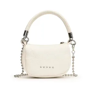 Dettaglio mini borsa bianca in pelle a grana con stelle d'argento e tracolla