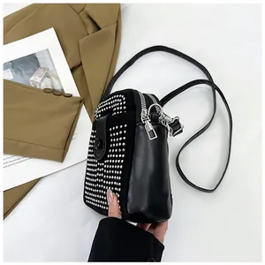 Top view of a black mini crossbody bag with silver studs and a slim leather strap