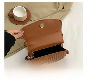 Detail showing internal capacity and caramel V-quilted texture of the crossbody bag