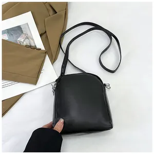 Detail shot of the black mini crossbody bag with silver zipper and slim shoulder strap