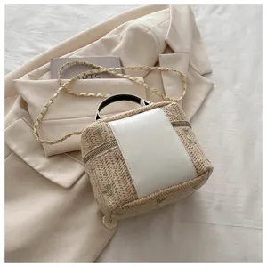 Detail of floral embroidery and straw weave texture on this elegant chain handbag