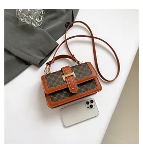 Flat lay of vintage monogram small square bag with leather trim and metal lock clasp