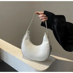 Detailed view of white hobo bag showing pebbled leather texture and silver hardware details