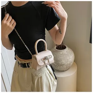 Chique mini crossbodytas met strass-strik en gouden ketting op een lifestyle model