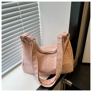 Close-up of light pink tote bag featuring unique pleated texture and wide shoulder strap