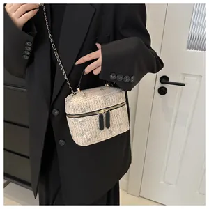 Detailed view of lace straw woven box bag featuring floral embroidery and chain strap