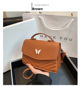 Brown PU leather small square bag with V-shaped quilting and white butterfly clasp detail
