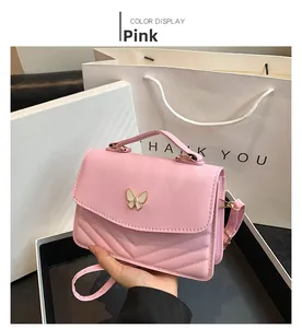 Detail of pink PU leather handbag featuring V-quilted texture and butterfly buckle
