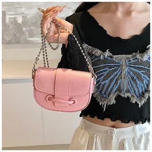 Détail du sac de selle en cuir grainé rose avec bandoulière en chaîne de perles argentées