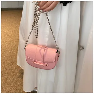 Détail du sac selle rose en cuir grainé avec bandoulière chaîne à billes argentées
