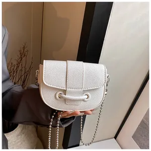 Gros plan d'un sac à main blanc grainé avec bandoulière en chaîne à billes argentée