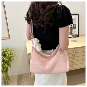 Close-up of light pink pleated tote bag with a cute white bear plush charm on the side
