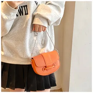 Détail du sac selle orange en cuir PU avec chaîne à billes argentée et fermoir à barre