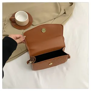 Internal view of brown V-quilted faux leather crossbody bag with golden magnetic clasp