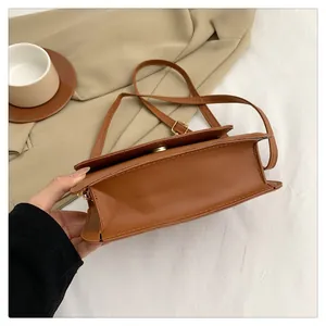 Detailed side view of brown PU leather small square bag with golden magnetic buckle