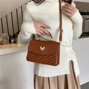 Brown leather crossbody bag with butterfly buckle and V-shaped chevron quilted texture