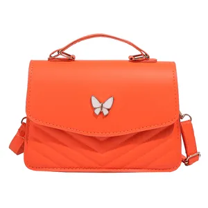 Modern orange crossbody bag with V-quilted faux leather and white butterfly clasp
