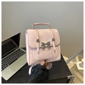 Close-up of pink textured backpack with a polished silver butterfly buckle detail