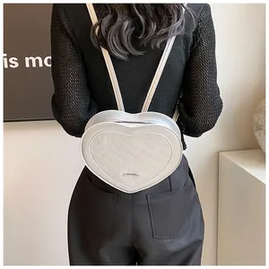 Detail of silver heart-shaped backpack featuring embossed rich rabbit lettering patterns