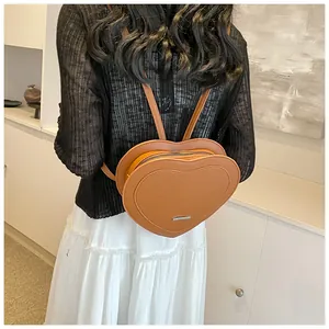 Detail view of heart-shaped brown backpack with embossed texture on model back