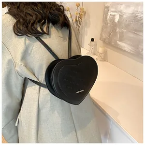 Detail view of heart-shaped backpack featuring Rich Rabbit embossed lettering and PU leather