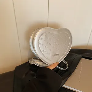 Detail of silver heart-shaped crossbody bag with rich rabbit embossed pattern textures