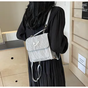 Detail of silver-grey backpack with butterfly metal buckle and pleated leather texture