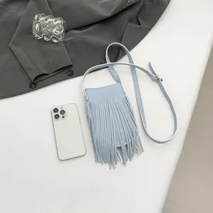 Stylish light blue tassel crossbody phone bag with adjustable strap on neutral background