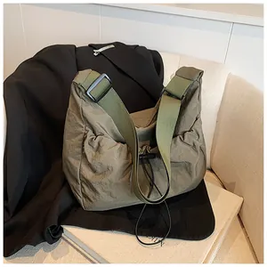 Detail of army green nylon tote bag with drawstring closure and wide adjustable strap