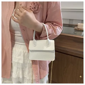 Détail du sac à main blanc à motif litchi avec une chaîne dorée chic et une poignée robuste
