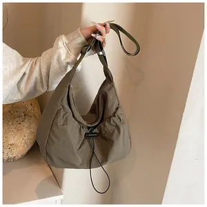 Detail of army green nylon tote bag featuring drawstring texture and adjustable strap