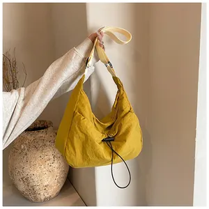 Detail of mustard yellow pleated tote bag with adjustable strap and drawstring toggle closure