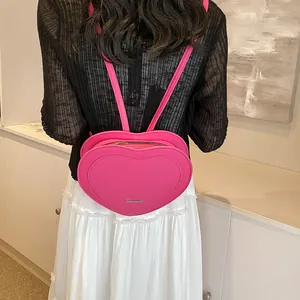 Stylish rose red heart-shaped backpack for women made of textured PU leather in casual style
