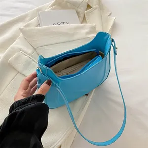Modern glossy blue underarm shoulder bag in patent leather finish with zipper closure