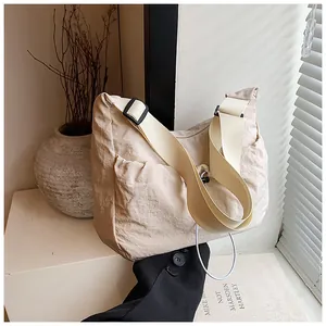 Detail of beige nylon tote bag featuring drawstring closure and textured ruched fabric