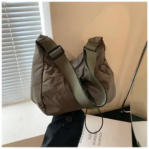 Detail of coffee brown nylon tote bag featuring adjustable olive green wide shoulder strap