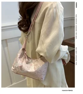 Détail de la texture jacquard rose et pompon perlé sur sac rétro de style chinois