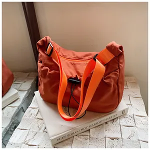 Detail of orange casual tote bag with drawstring closure and wide shoulder strap